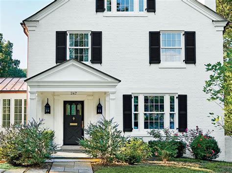 white house with black shutters and metal roof|charcoal shutters on white house.